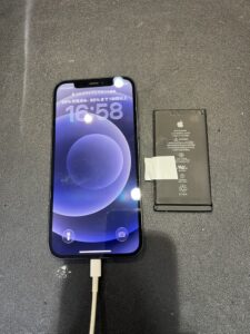 バッテリー交換後のiPhone 12と、取り外した古いバッテリー
