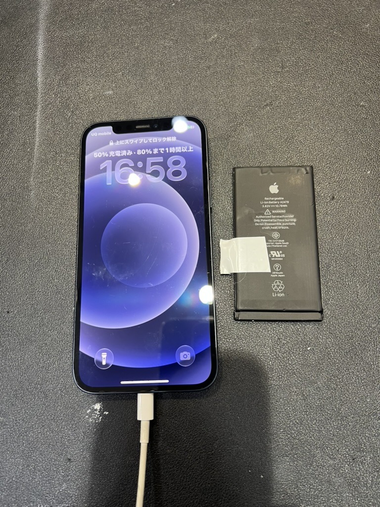 バッテリー交換後のiPhone 12と、取り外した古いバッテリー